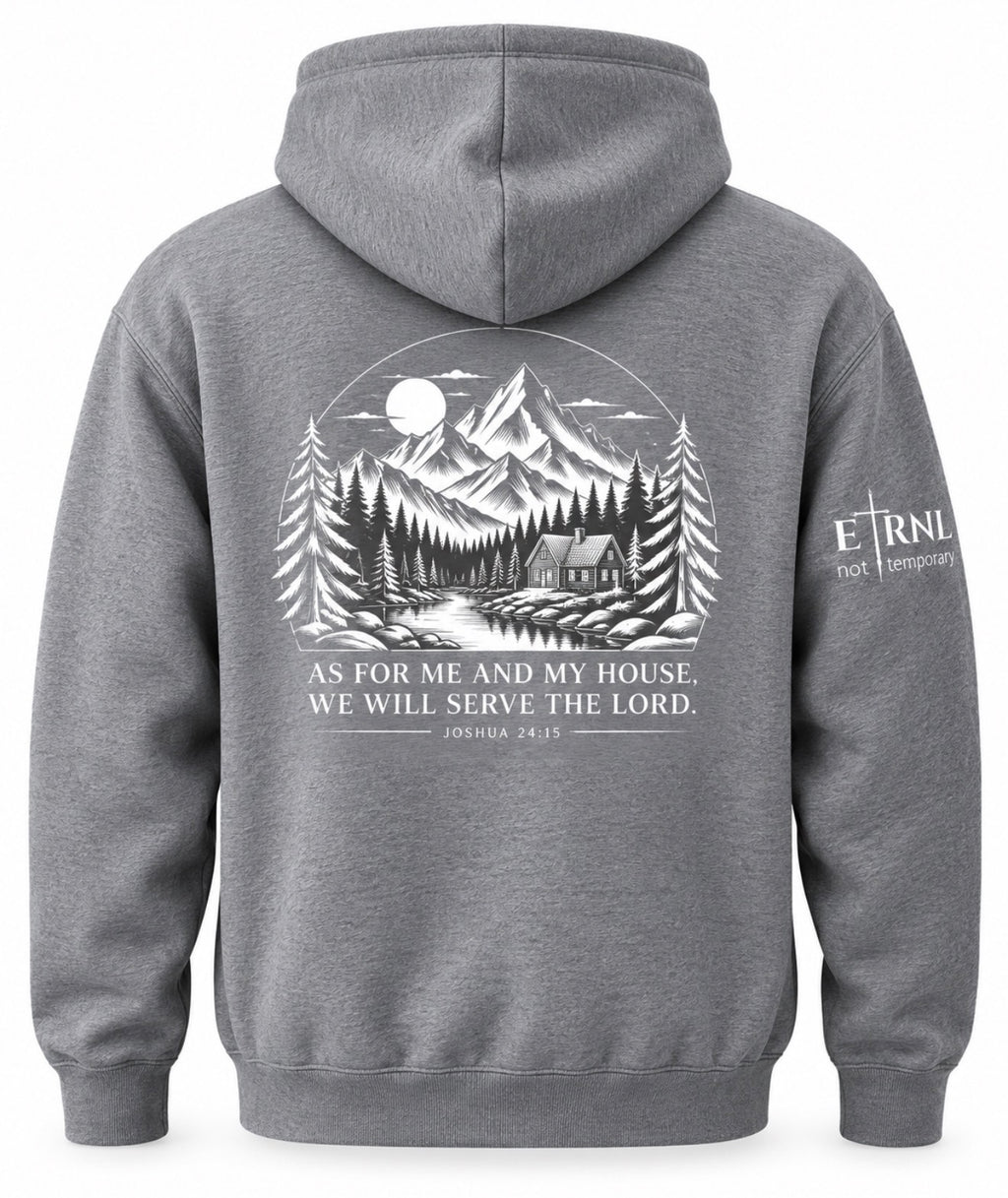 A gray pullover hoodie shown from the back, featuring a large white graphic print of a mountain cabin scene with a moon and the text 'AS FOR ME AND MY HOUSE, WE WILL SERVE THE LORD' with a Bible verse below. A smaller white 'ETRNL - Not Temporary' logo is printed on the left sleeve.