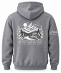 A gray pullover hoodie shown from the back, featuring a large white graphic print of a mountain cabin scene with a moon and the text 'AS FOR ME AND MY HOUSE, WE WILL SERVE THE LORD' with a Bible verse below. A smaller white 'ETRNL - Not Temporary' logo is printed on the left sleeve.
